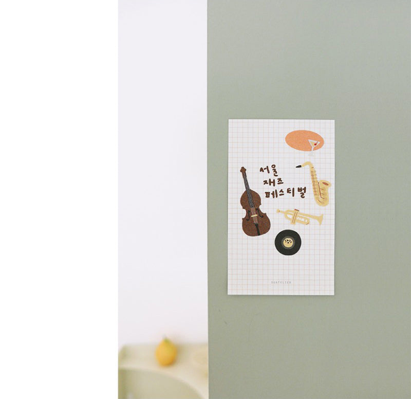 Sheet music with musical instruments on a light green wall.