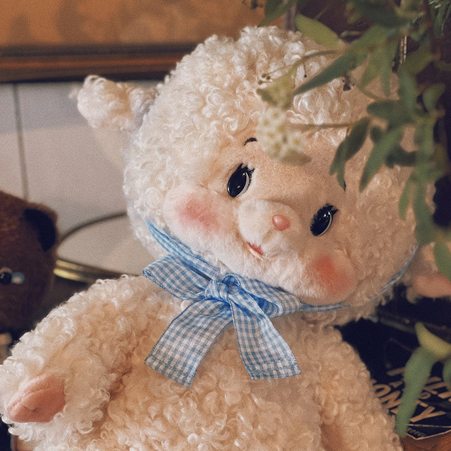 Stuffed animal toy with a blue bow tie in a home setting
