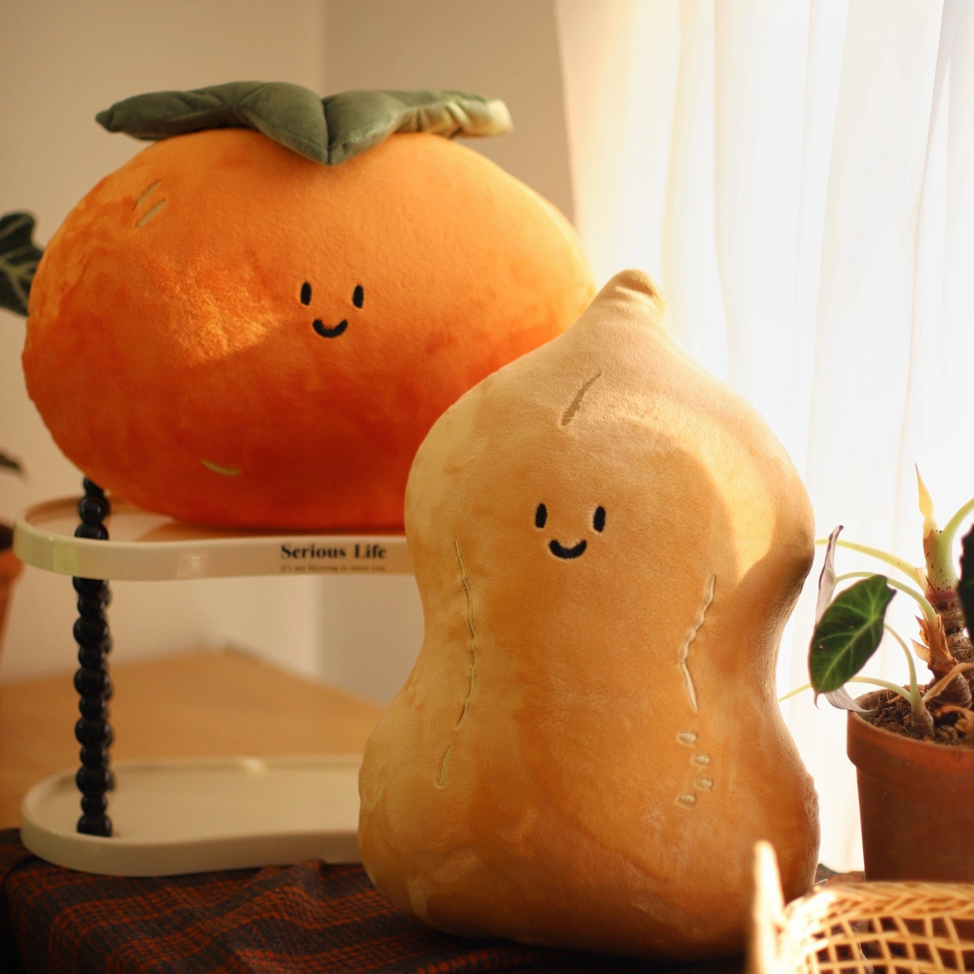 Plush toy shaped like a persimmon and a peanut on a surface