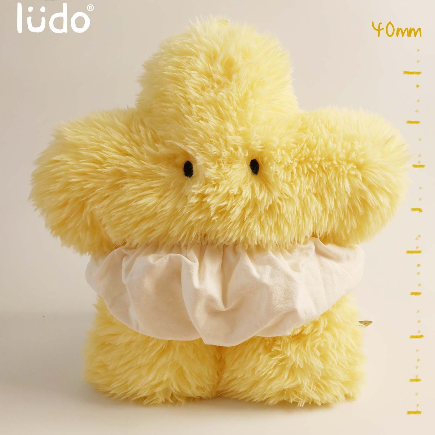 Yellow plush duck toy with a white shirt on a beige background, featuring the lédo brand.