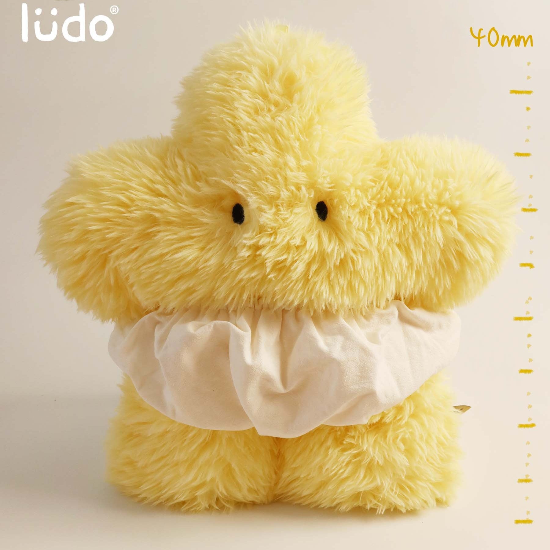 Yellow plush duck toy with a white shirt on a beige background, featuring the lédo brand.